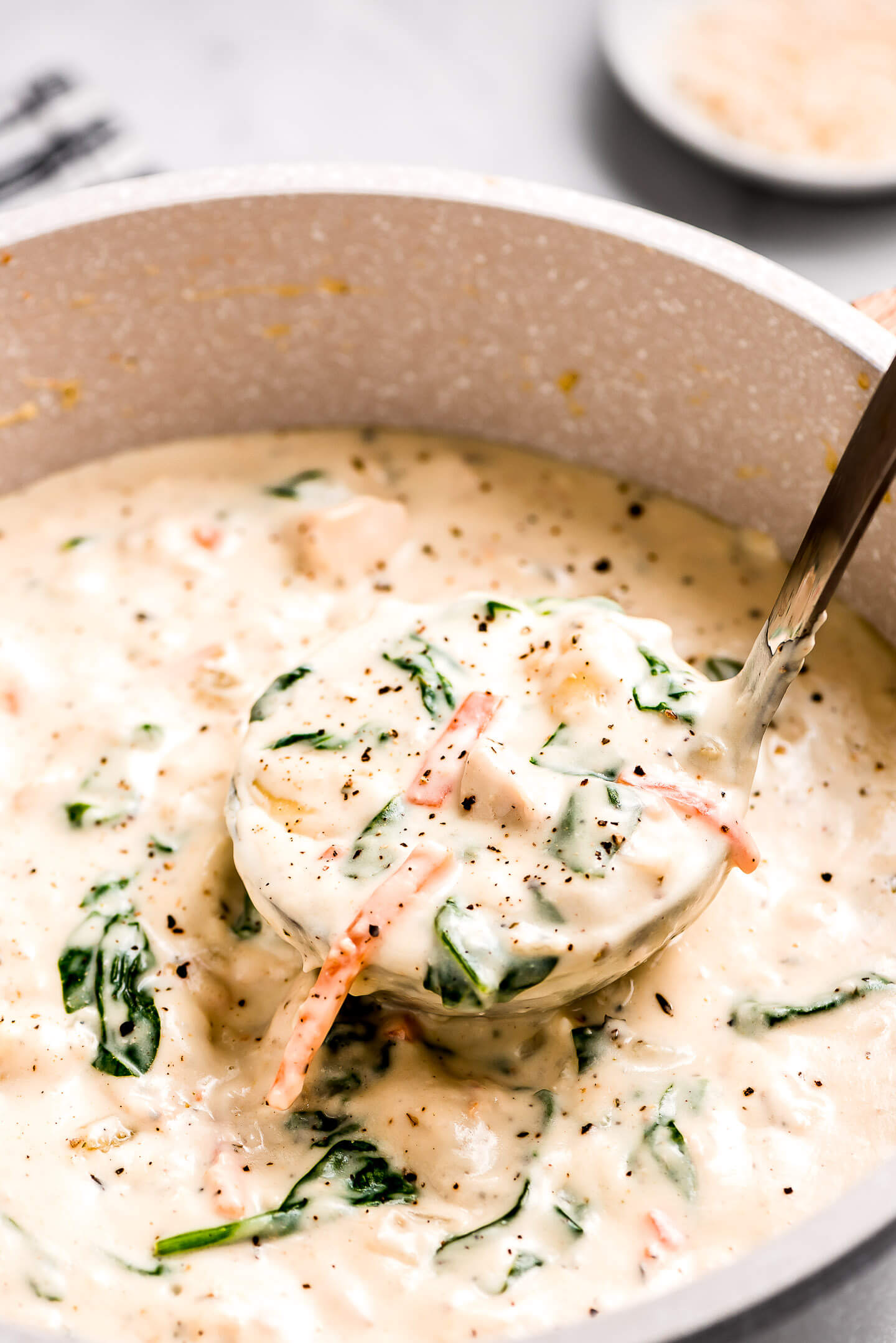 Lifting a ladle out of a pot of Olive Garden Chicken Gnocchi Soup.