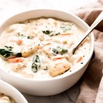 A close up of a spoon in a bowl of Chicken Gnocchi Soup.