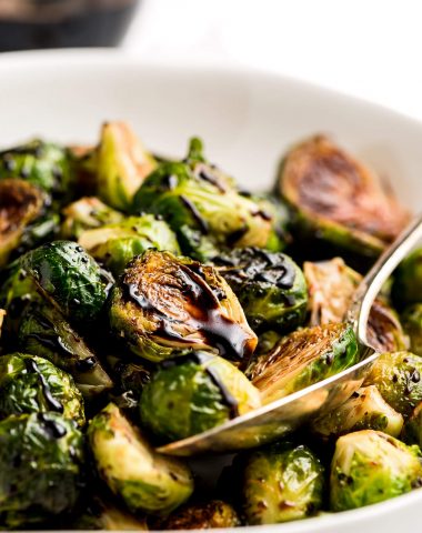 Balsamic Brussel Sprouts in a serving bowl with a spoon.