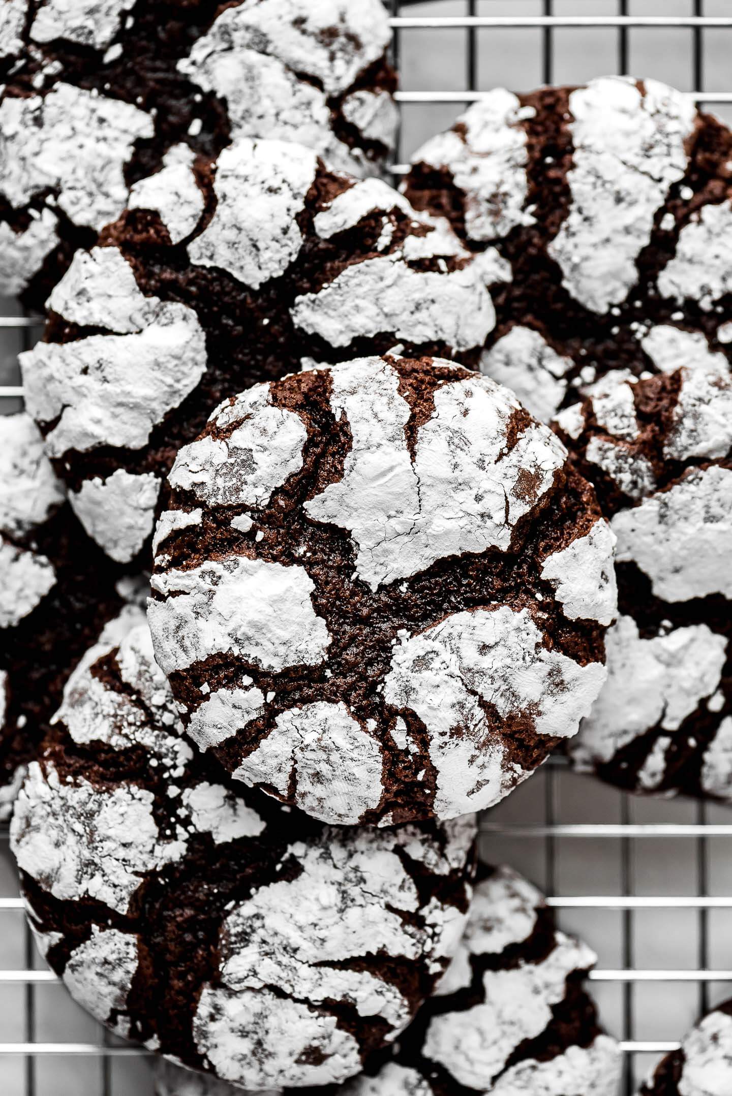 Close up shot of the fudge cracks in a chocolate cookie covered with powdered sugar.