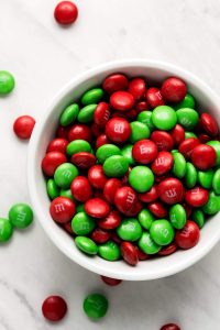 A close up of red and green Christmas M&M's in a bowl.