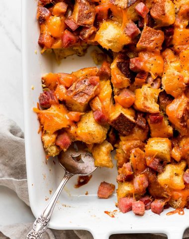 Close up photo of Ham and Cheese Breakfast Casserole in a white casserole dish.