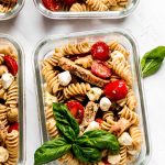 Multiple glass meal prep containers with Pesto Pasta Salad.