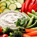 A platter of fresh vegetables and a bowl of Veggie Dip.
