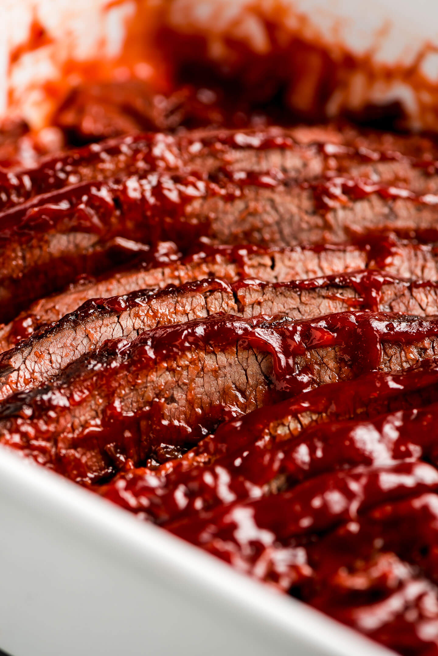 Close up shot of sliced Beef Brisket with barbecue sauce on the top edges.