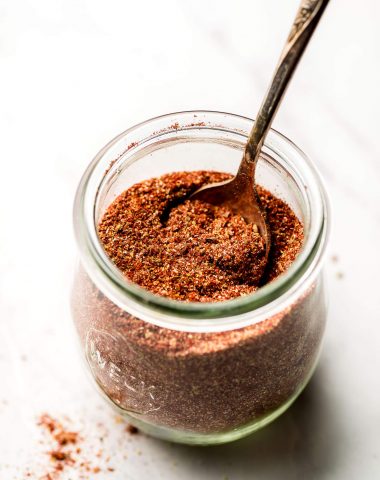 A jar of Homemade Taco Seasoning with a spoon in it.