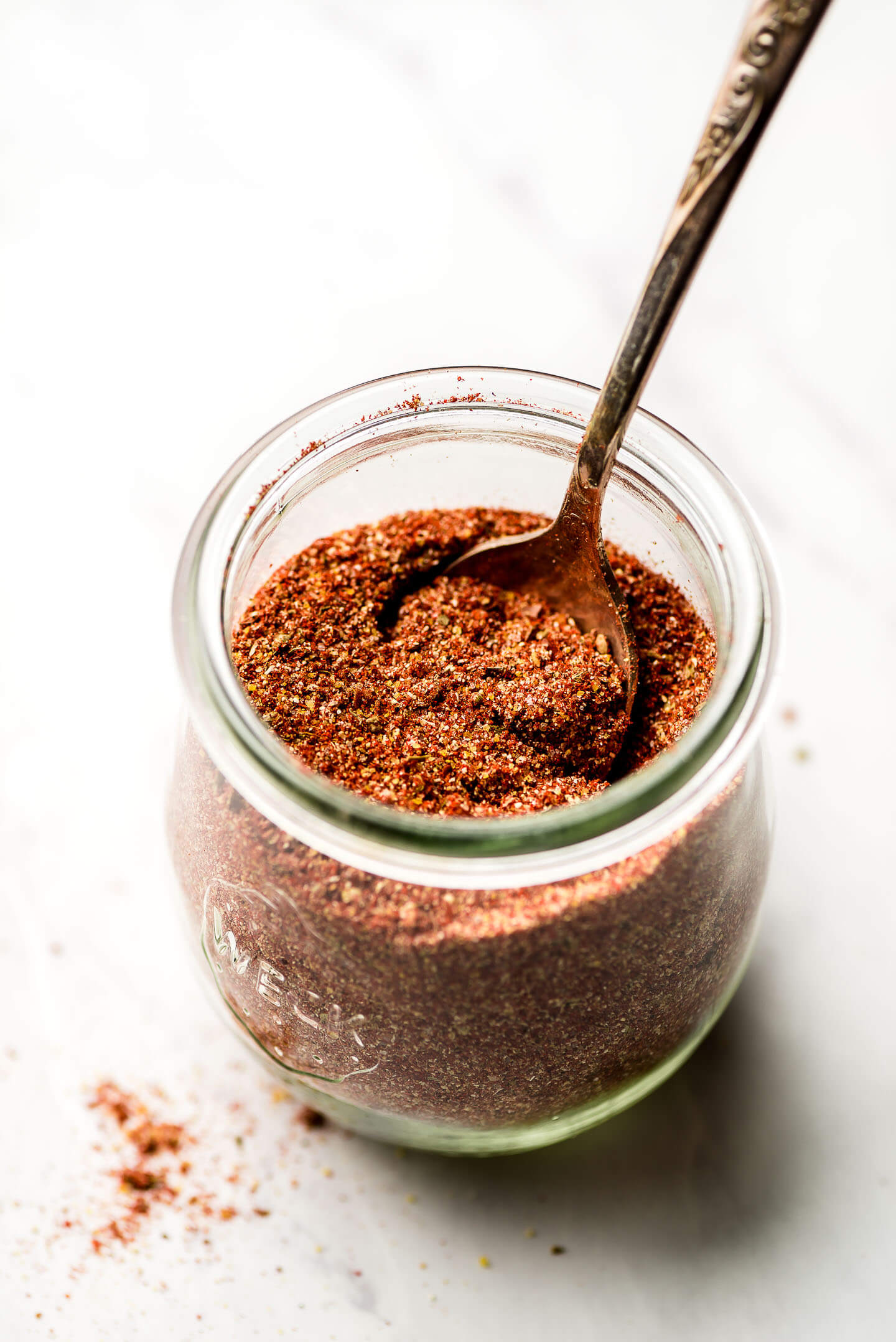A jar of Homemade Taco Seasoning with a spoon in it.