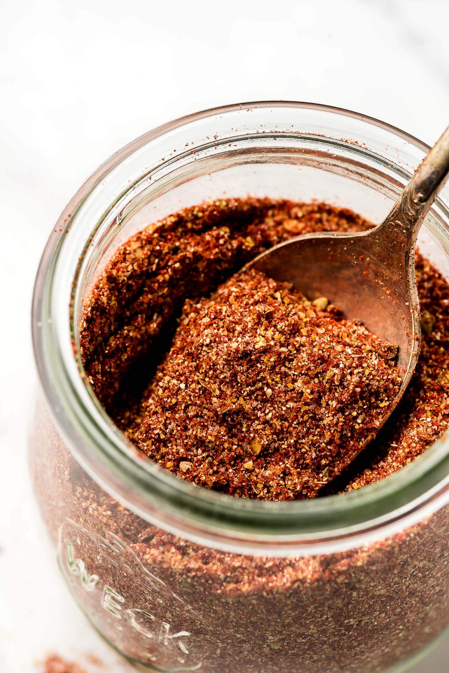 Close up shot of Taco Seasoning on a spoon in a jar.