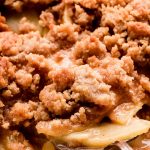 Close up shot of lifting cooked apples with a streusel on top.
