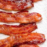 Strips of Oven Baked Bacon on a paper towel.