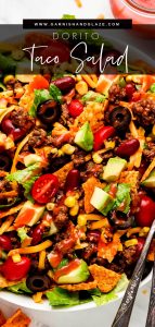 Close up shot of Doritos Taco Salad drizzled with Catalina dressing and two forks in the side.
