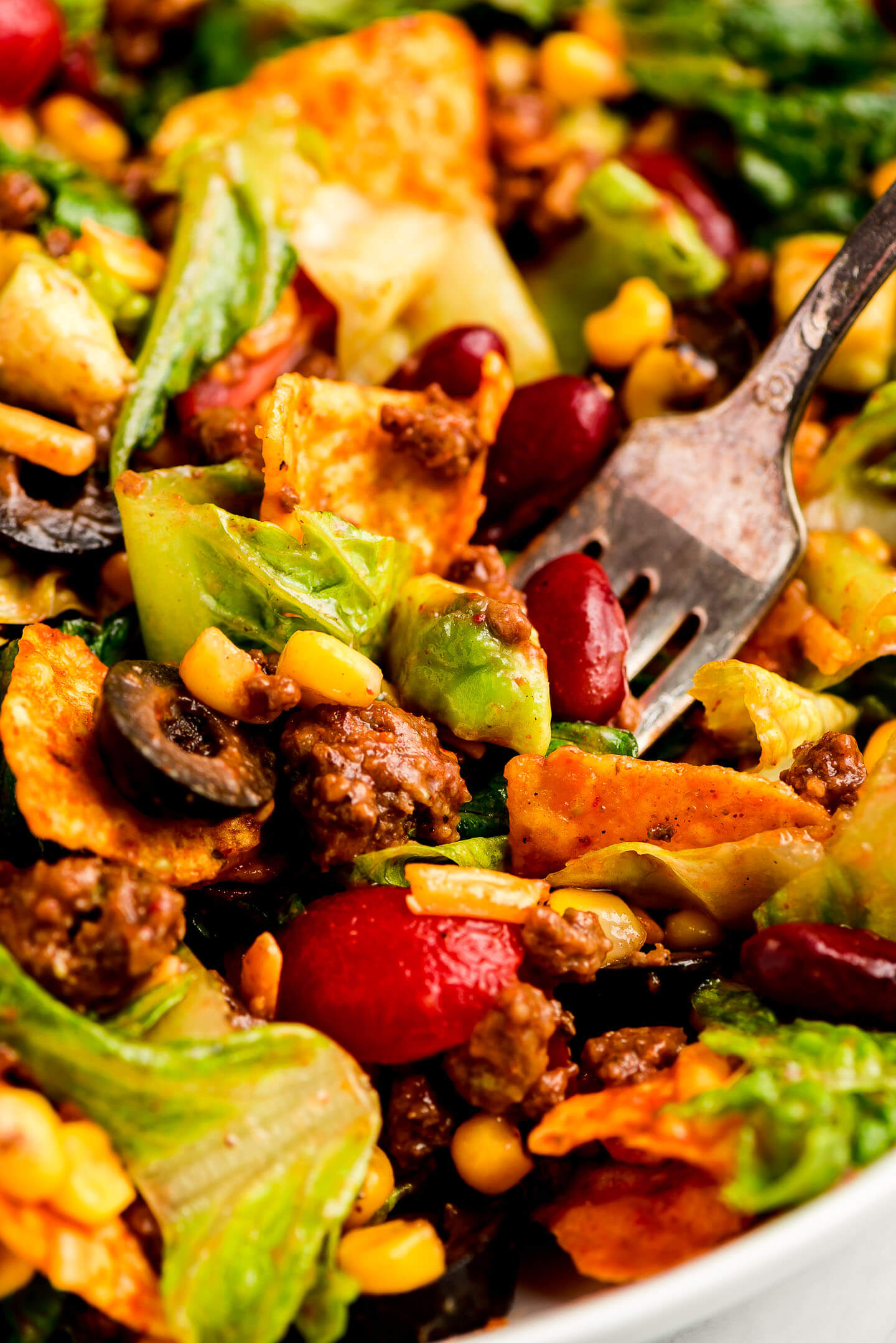 Close up shot of a fork full of Taco Salad.
