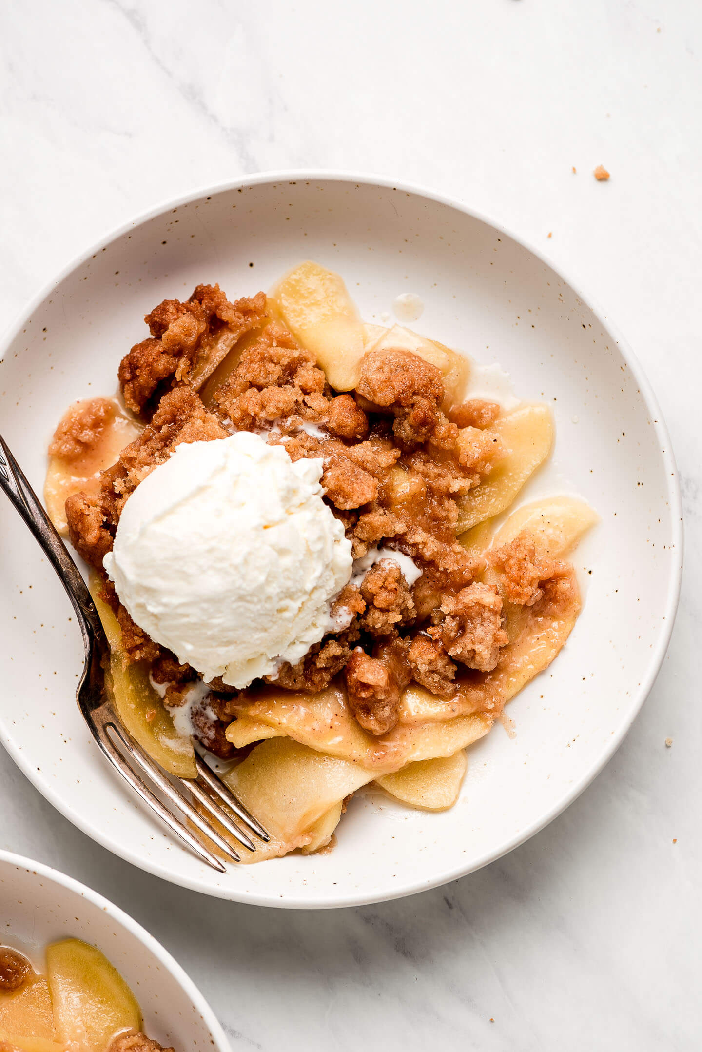 Top view of Apple Crisp in a bowl with a fork in the side.