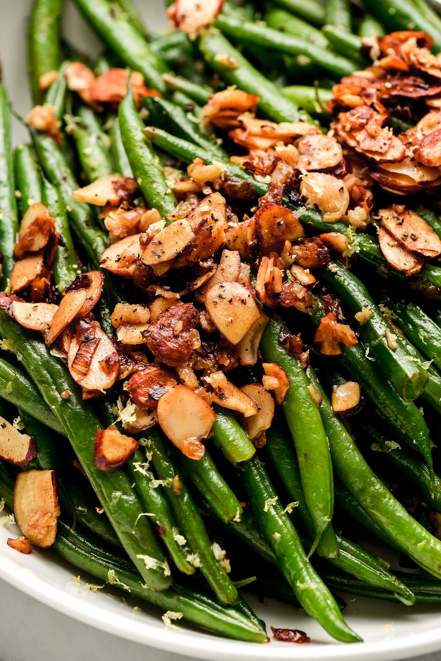 Close up shot of toasted almonds on green beans.