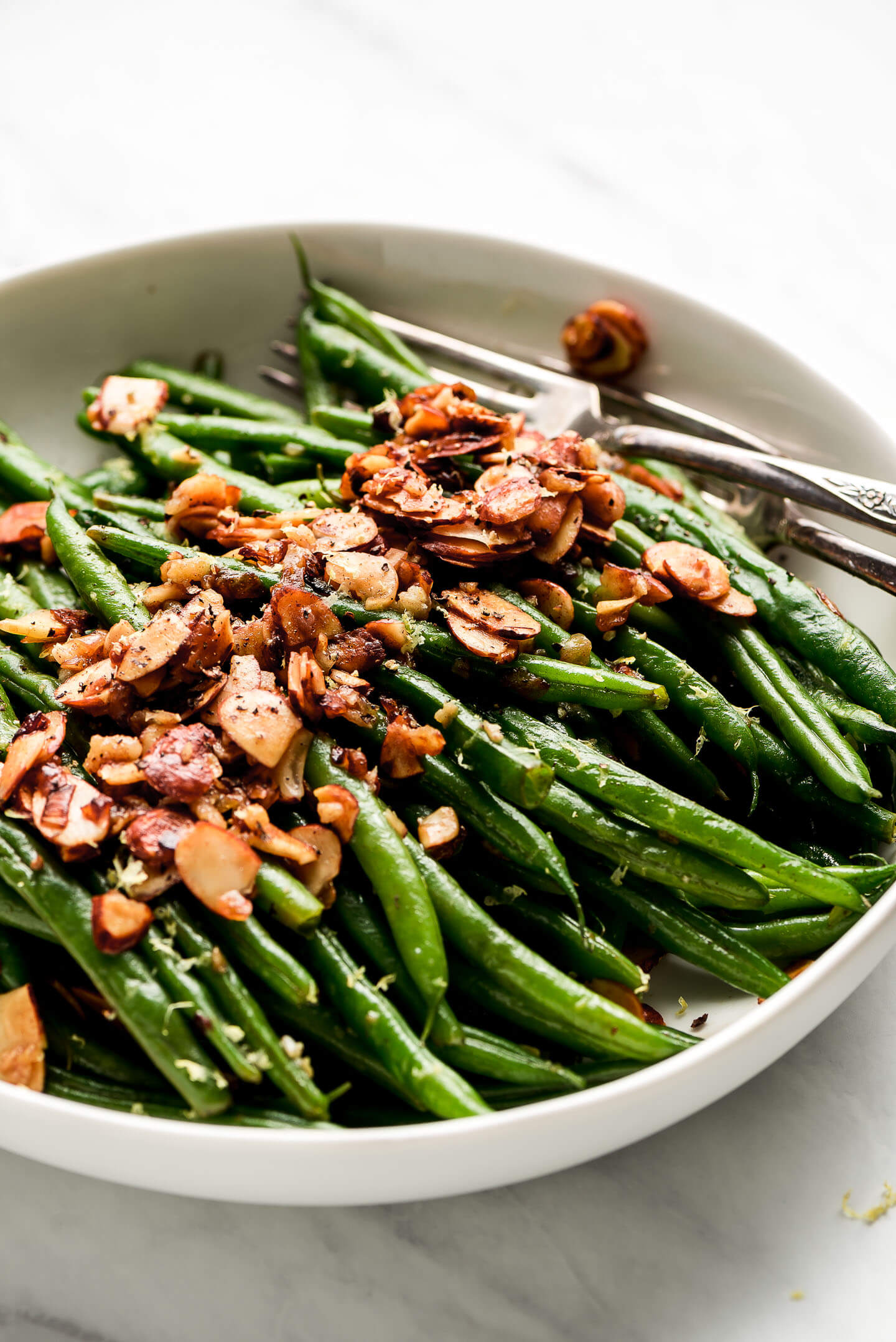 Side view of a bowl of Green Beans Almondine.