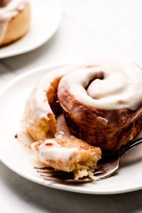 Close up shot of a Cinnamon Roll unwound and a piece on a fork.