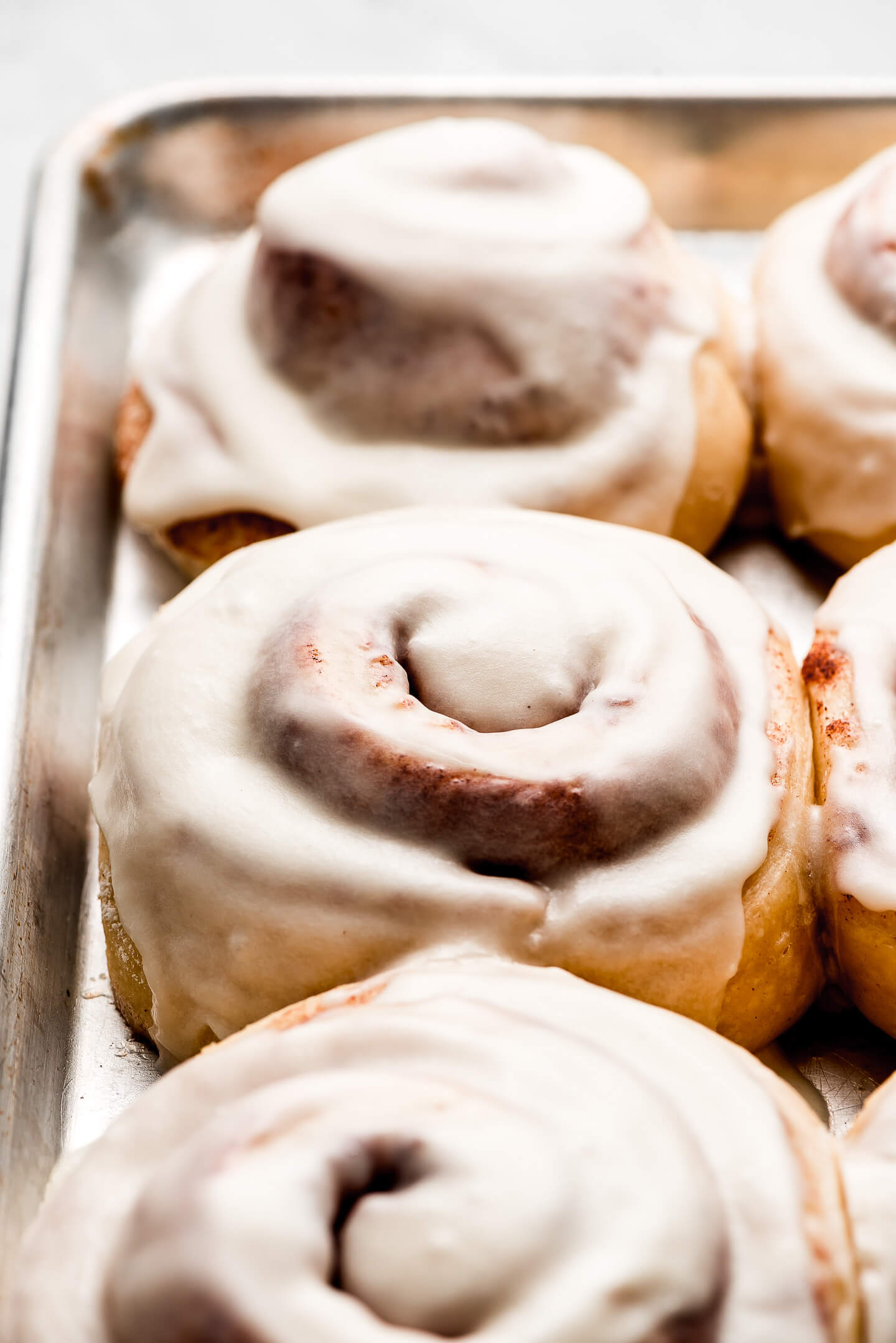 Close up shot of a iced sweet roll on a pan.