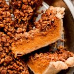 Close up shot of a piece of Streusel Pumpkin Pie on its side in a pie tin.