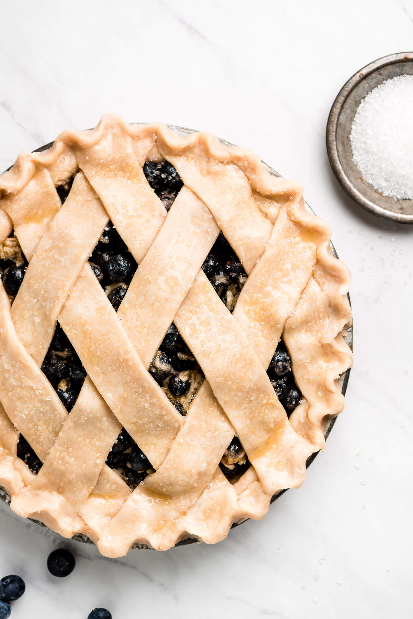 Uncooked lattice pie sprinkled with coarse sugar.