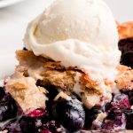Close up shot of a half eaten piece of pie with ice cream.