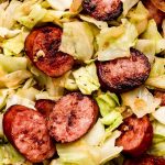 Close up shot of smoked sausage and cooked cabbage.