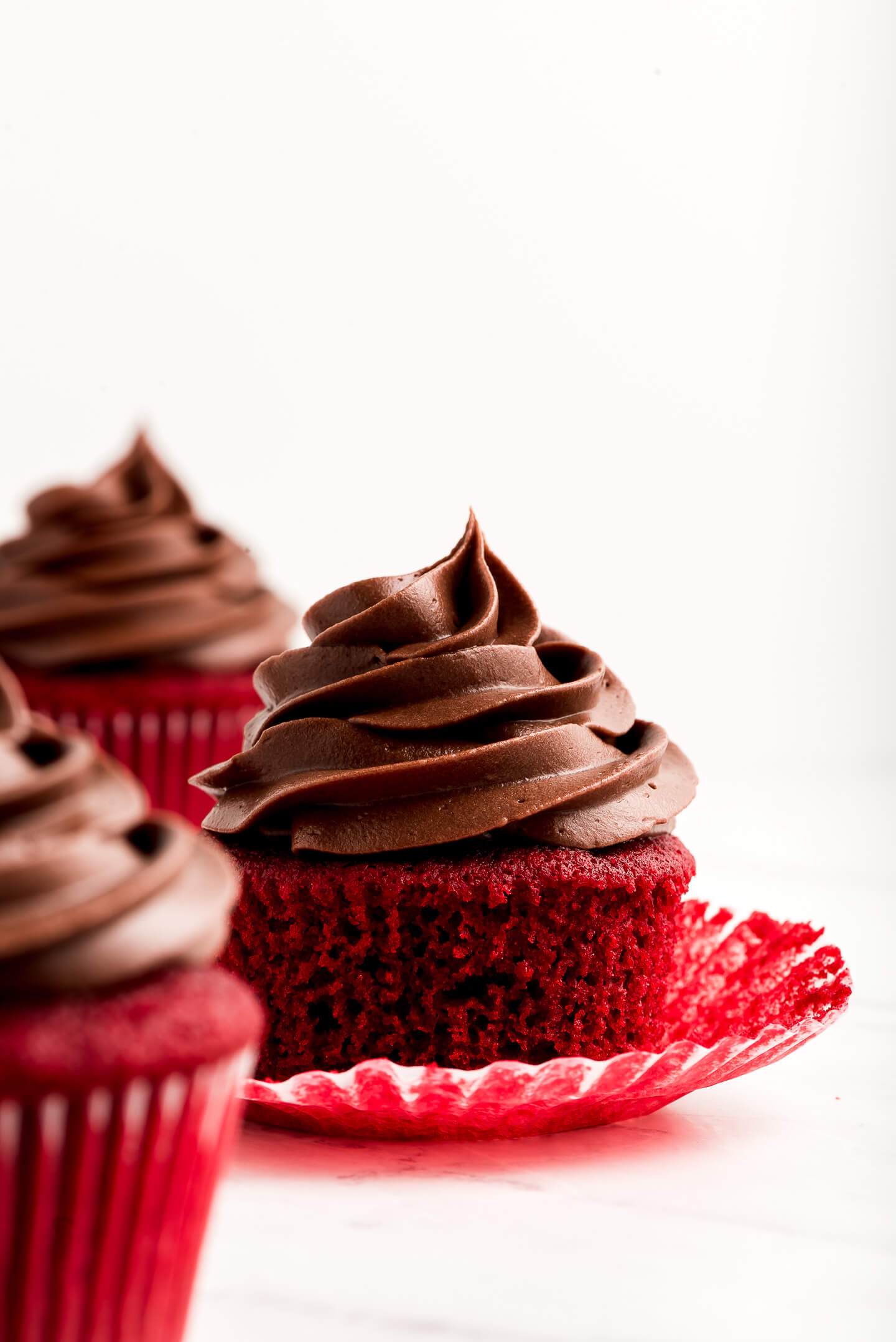 Red cupcake topped with Chocolate Cream Cheese Frosting.