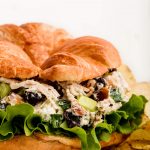 Close up of Chicken Salad on a croissant with green leaf lettuce.