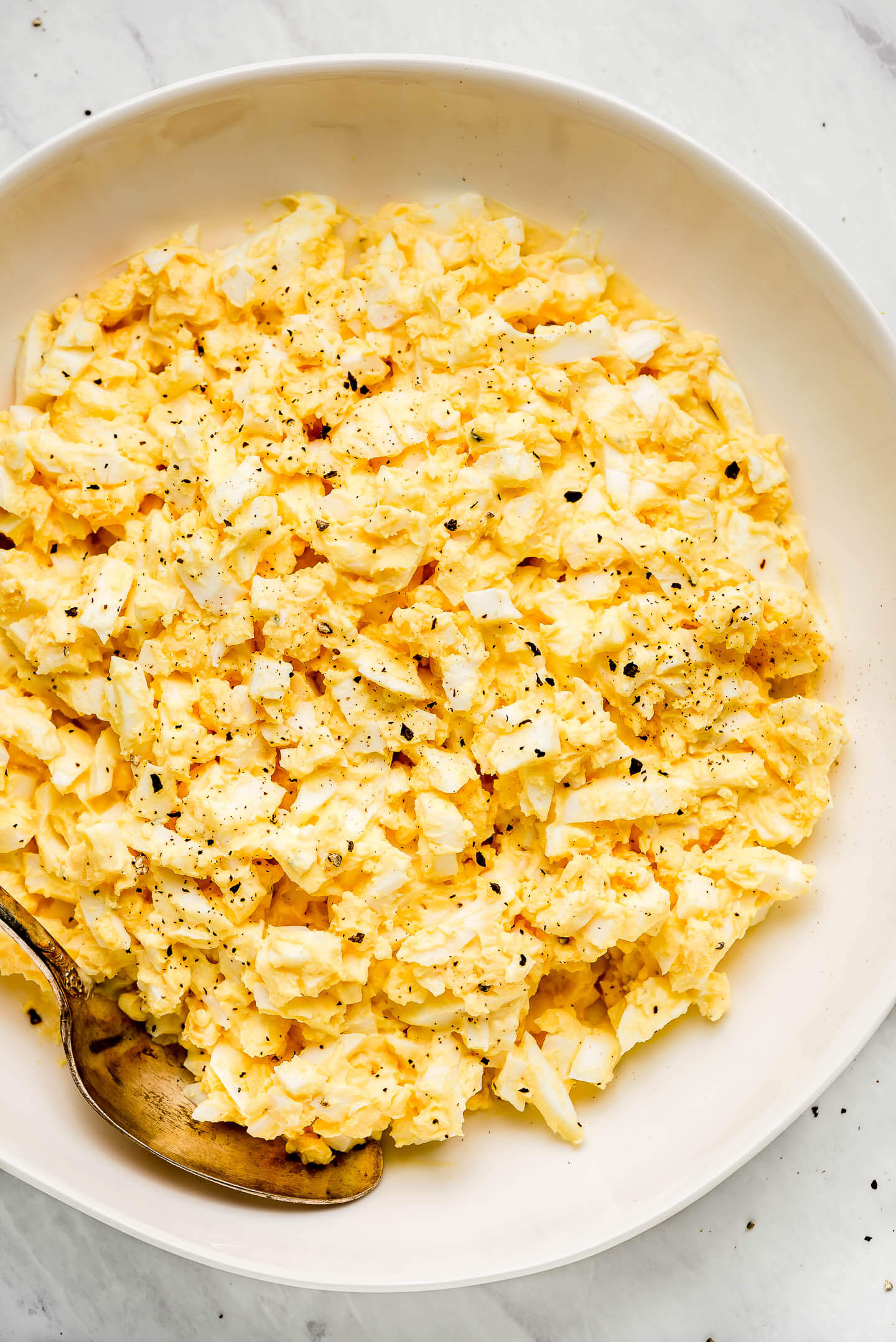 Egg Salad in a bowl sprinkled with pepper.