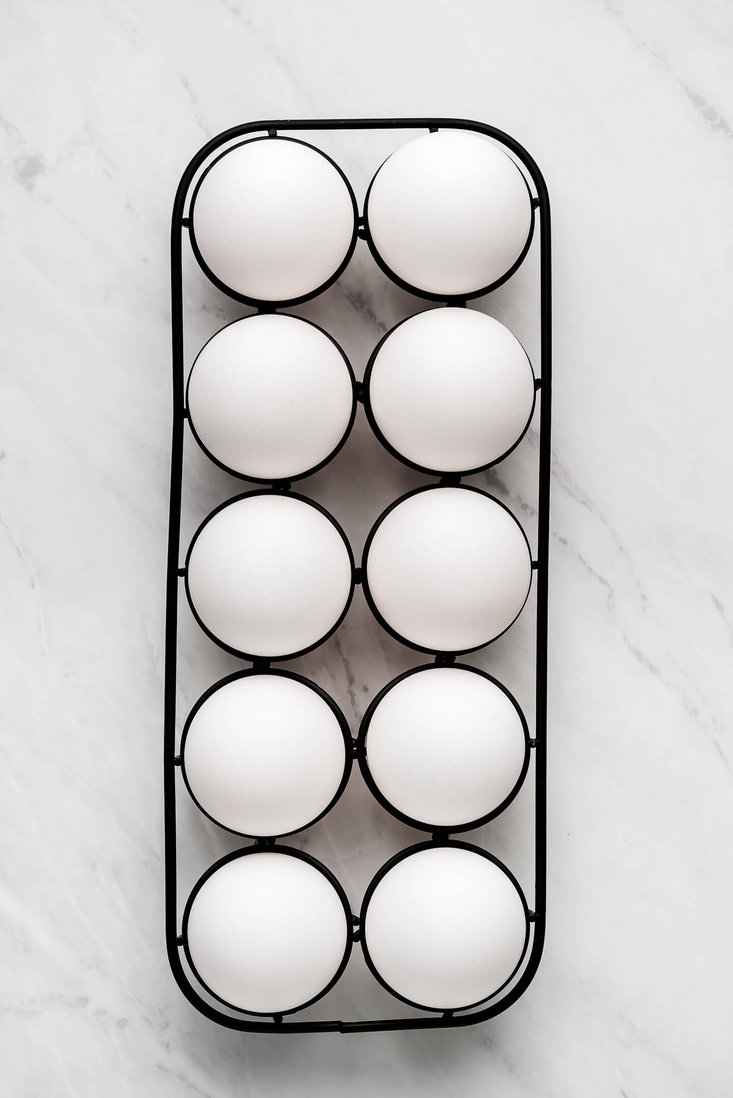 Eggs on a metal rack on a marble surface.