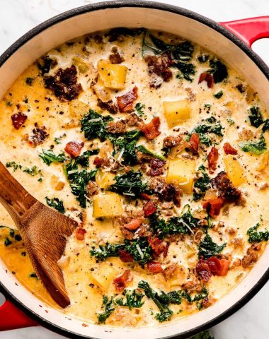 A pot of Zuppa Toscana soup garnished with parmesan cheese.