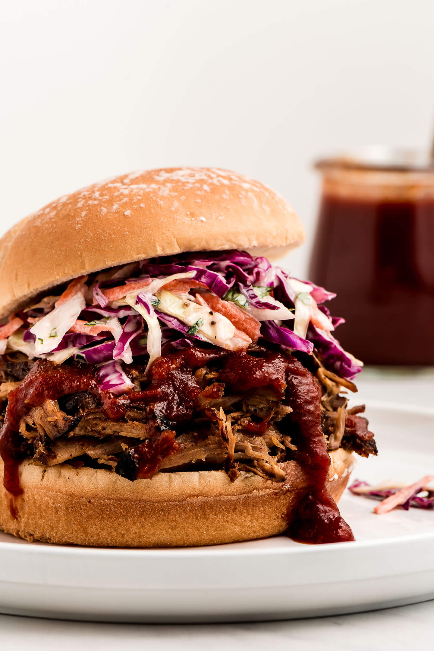 A close up shot of a pulled pork sandwich with coleslaw on it.