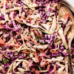 Coleslaw in a white serving bowl.