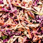 Coleslaw in a white serving bowl.