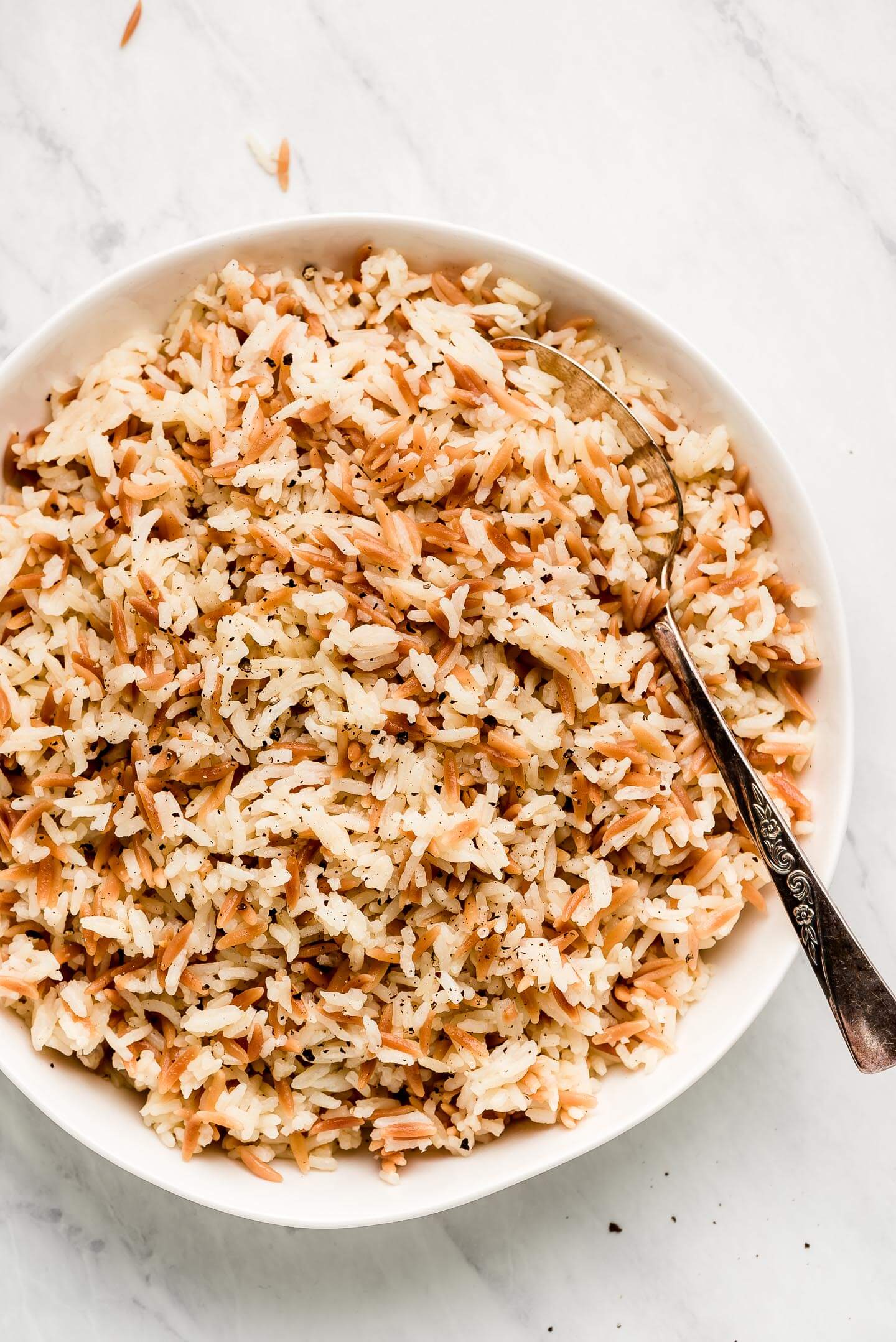 A white serving bowl of Orzo Rice.
