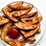 Baked Potato Wedges on a plate with ketchup.