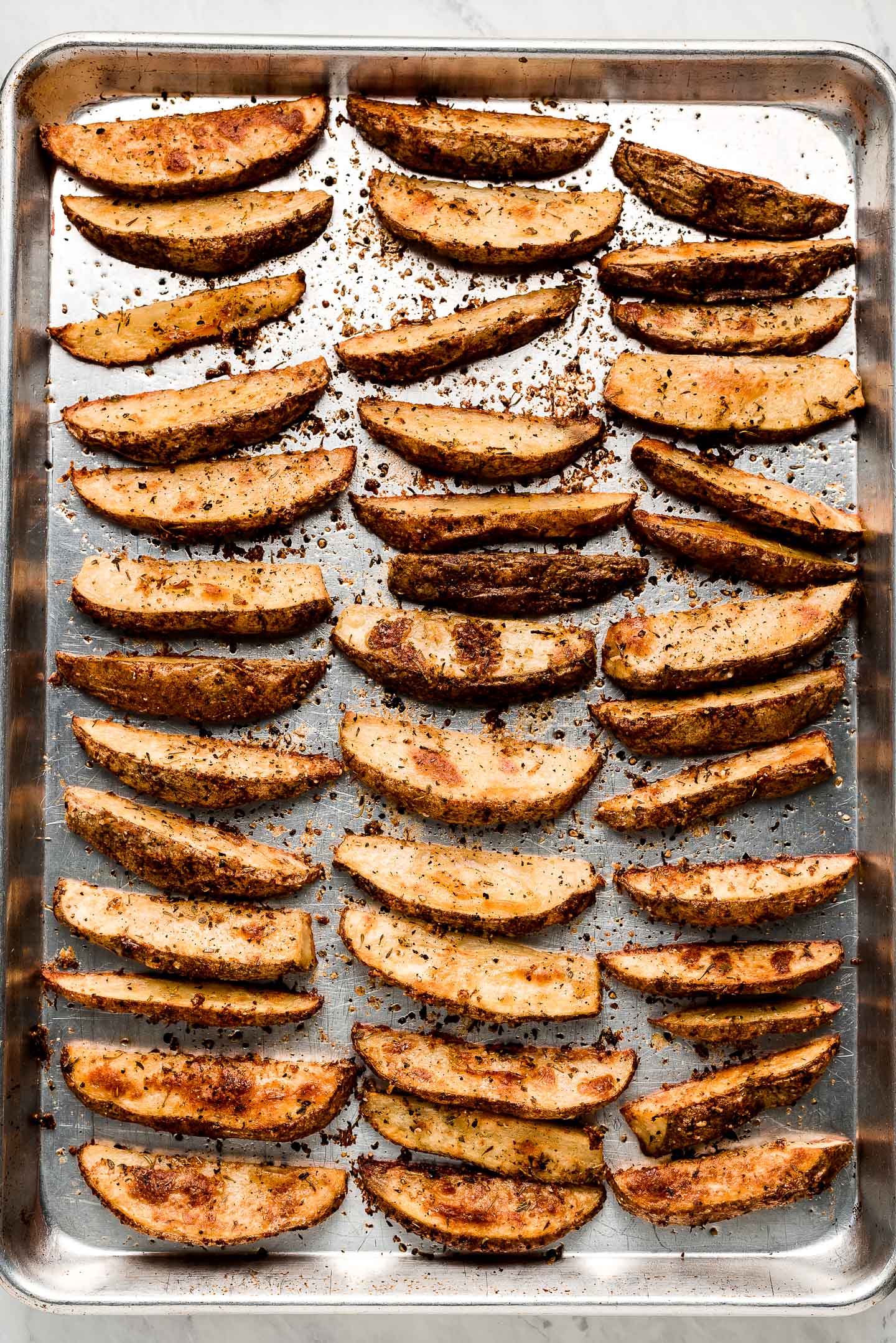 Seasoned Baked Potato Wedges on a baking sheet.