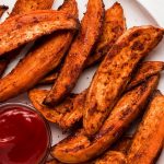 Baked Sweet Potato Wedges on a plate with ketchup.
