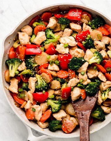 Chicken Stir Fry with vegetables and garnished with green onion and sesame seeds.
