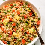 Fried Rice with carrots, peas, eggs, and green onion in a serving bowl.