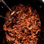 Shredded BBQ chicken in a slow cooker.