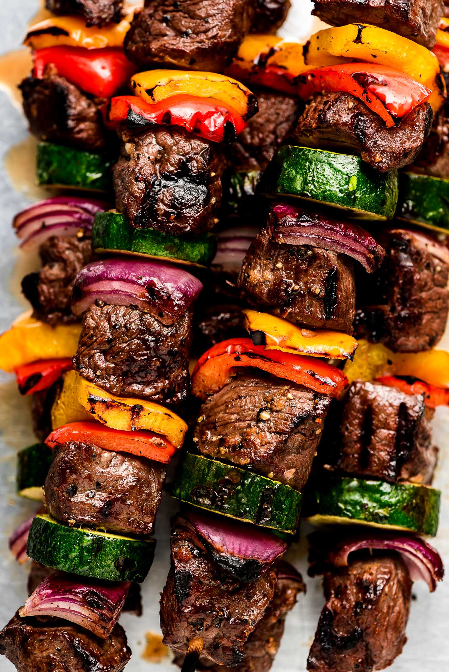 Closeup of Steak Kabobs with peppers, onion, and zucchini.