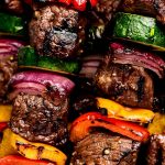 Closeup of Steak Kabobs with peppers, onion, and zucchini.