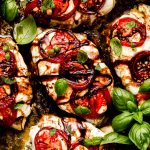 Chicken covered in mozzarella cheese and topped with tomatoes, basil, and balsamic glaze.