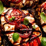 Chicken covered in mozzarella cheese and topped with tomatoes, basil, and balsamic glaze.