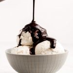 Pouring Chocolate Syrup over ice cream.
