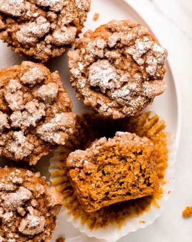 Pumpkin Streusel Muffins on a plate with one cut in half to show inside.