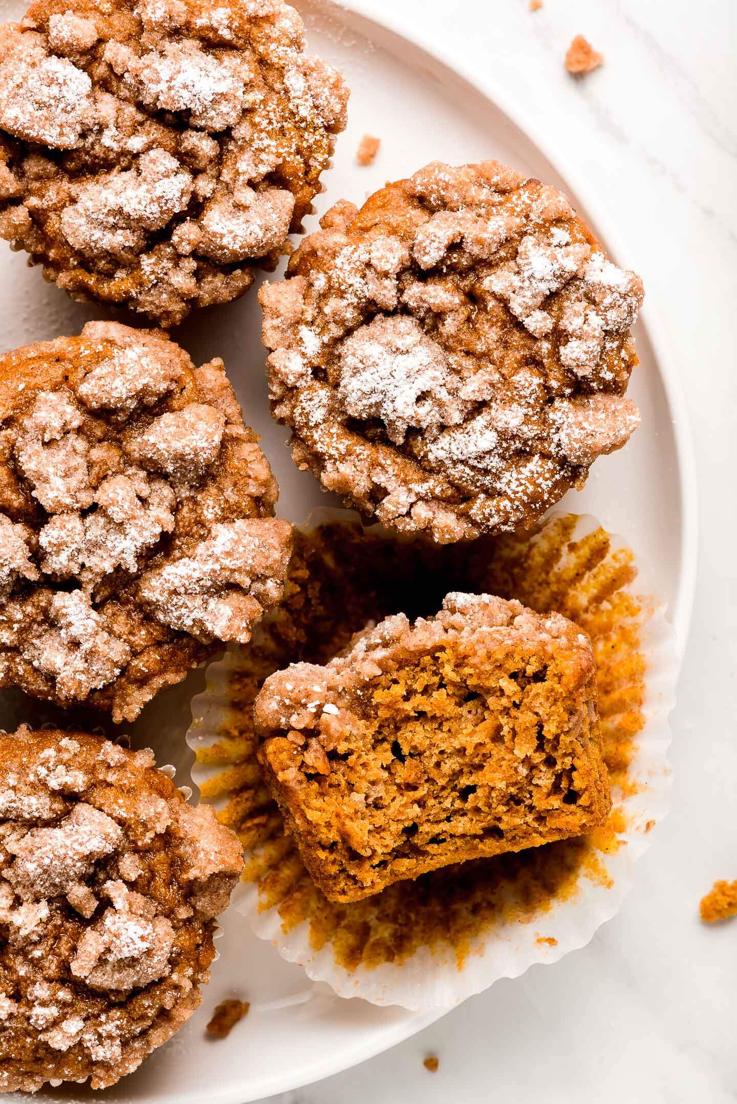 Pumpkin Streusel Muffins on a plate with one cut in half to show inside.