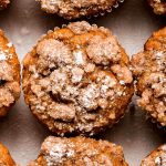 Close up of the top of Pumpkin Streusel Muffins dusted with powder sugar.
