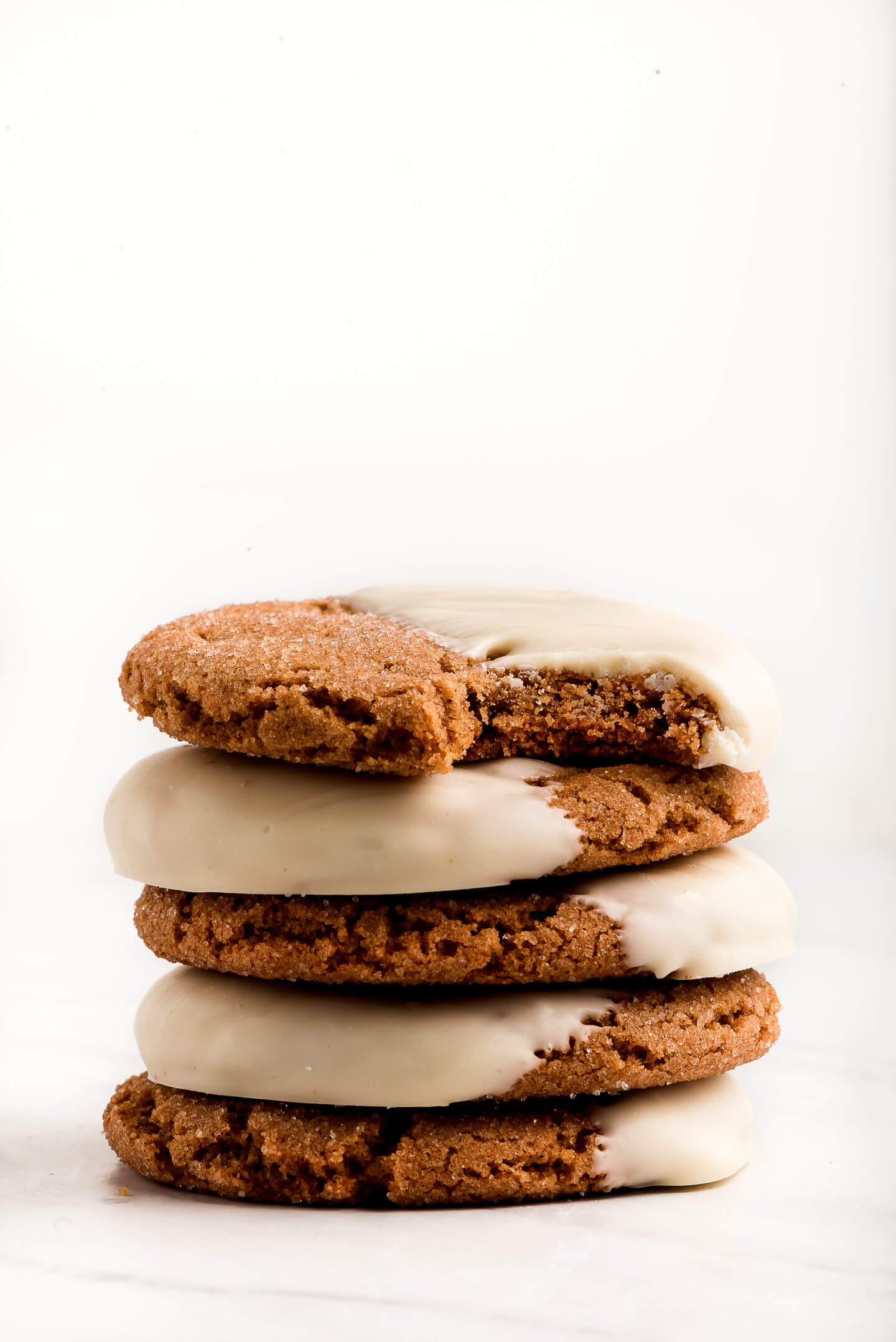 A stack of Gingersnaps with a bite taken out of the one on top.