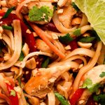 Close up of Chicken Pad Thai garnished with cilantro and peanuts.